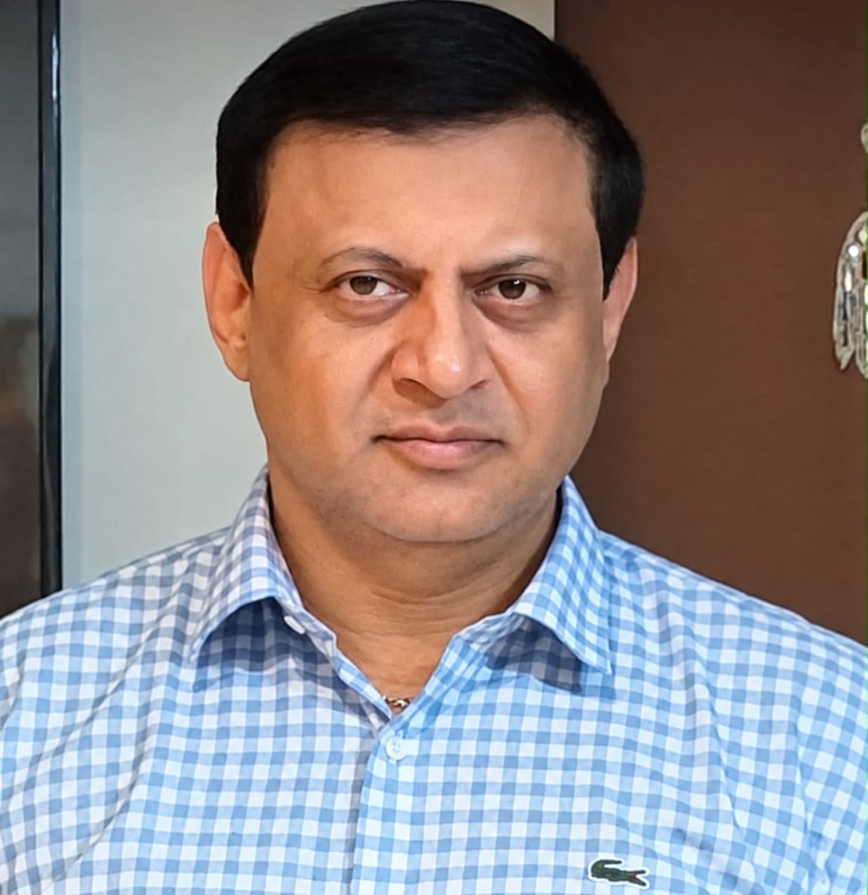 Portrait of Deepak Thimaya in a blue check shirt